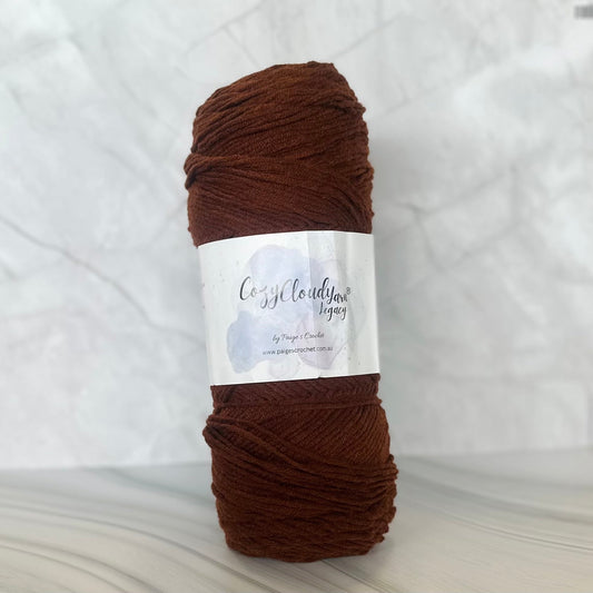 Brown skein of yarn with a label on a white background